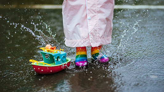 下雨天穿雨鞋的小朋友玩水图片