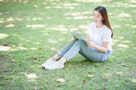 坐在校园草坪上看书的女学生图片