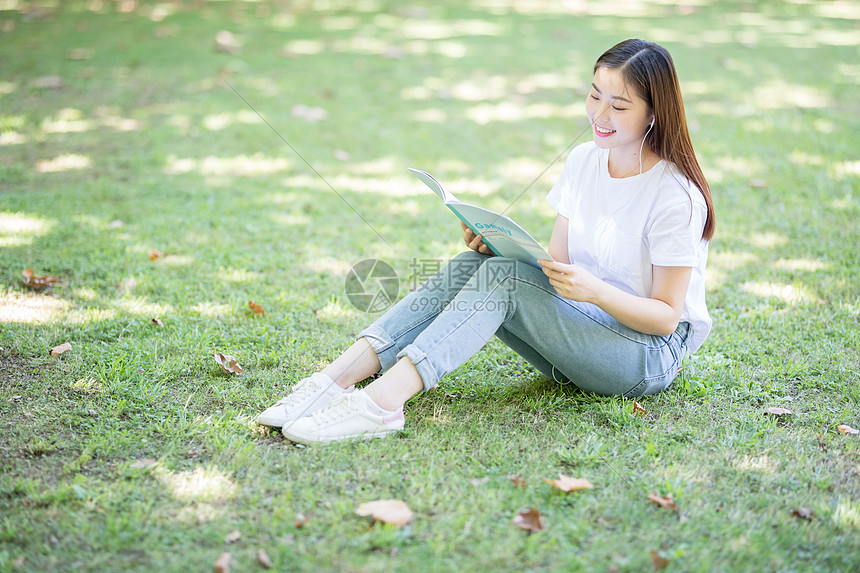 坐在校园草坪上看书的女学生图片