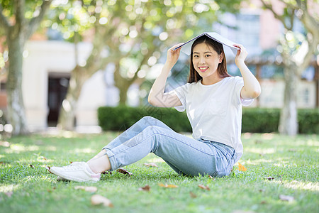 坐在校园草坪上看书的女学生图片