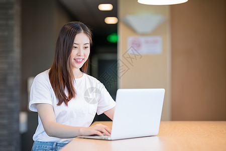 看电脑使用的电脑的年轻女性图片