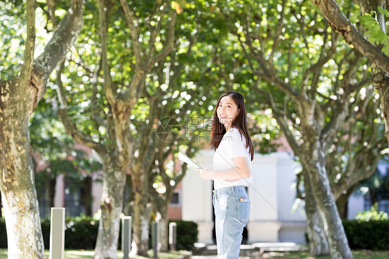 走在校园林荫道下的甜美女生图片