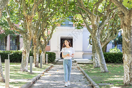 走路看书迎面走里的美女大学生背景