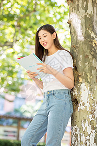 校园里靠在大树边看书的女生图片