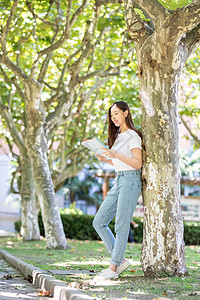 校园里靠在大树边看书的女生图片