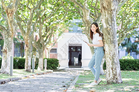 校园里靠在大树边看书的女生图片