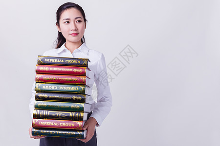 干练的商务女性抱着书籍思考图片