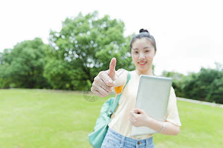 校园草地前女生举大拇指图片