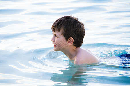小男孩侧面在游泳的小男孩背景