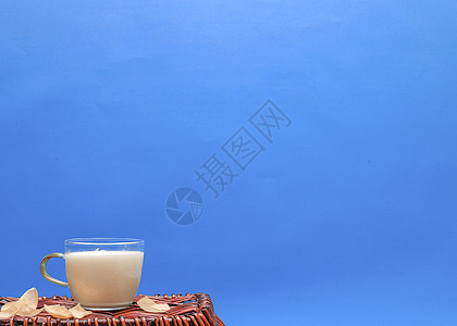 一杯牛奶放在竹篮上图片