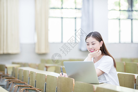 书桌背景教室里使用笔记本电脑学习的学生背景