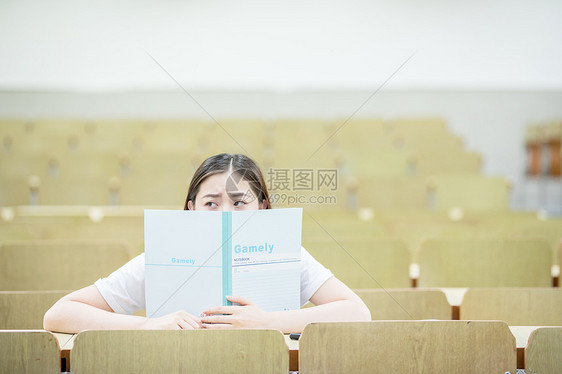 教室里用书挡着脸的可爱女生图片