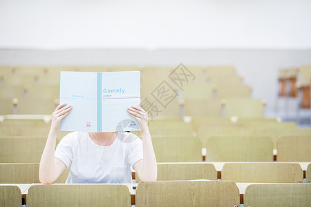 教室里用书挡着脸的可爱女生图片