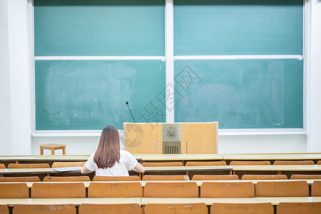 大学阶梯教室空旷的教室里正在学习的女生背影背景