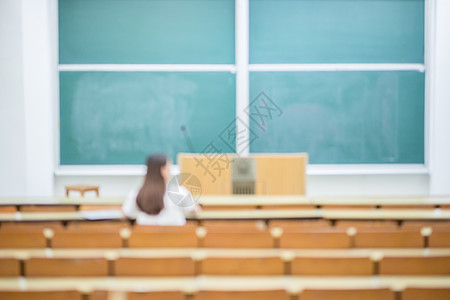 空旷的教室里正在学习的女生背影图片