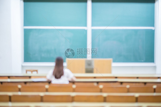 空旷的教室里正在学习的女生背影图片