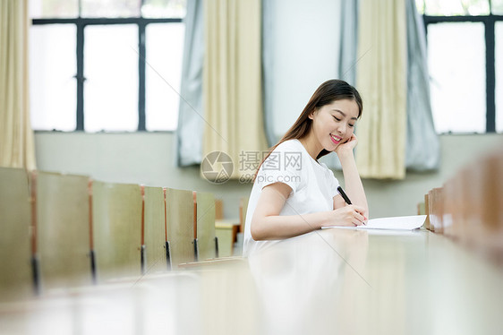 教室里自习学习写字的女大学生图片