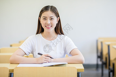 书桌学习坐在教室里认真学习的大学生背景