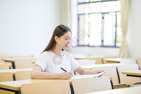 教室里自习学习写字的女大学生图片