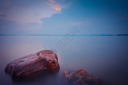 武汉东湖长曝光雾化湖面和礁石背景图片