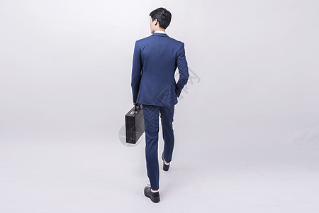自信蓝色商务人士拎包行走背景