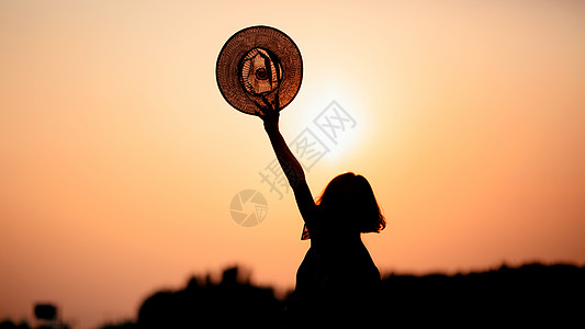 帽子背影夕阳下的女性背影背景