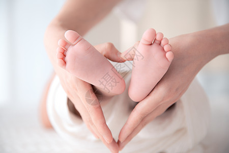 孩子妈妈手环抱婴儿脚丫照片背景