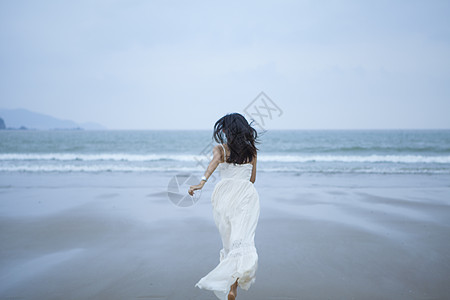 海边奔跑的女性背影图片