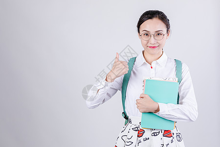 背包女生抱着书本形象棚拍图片