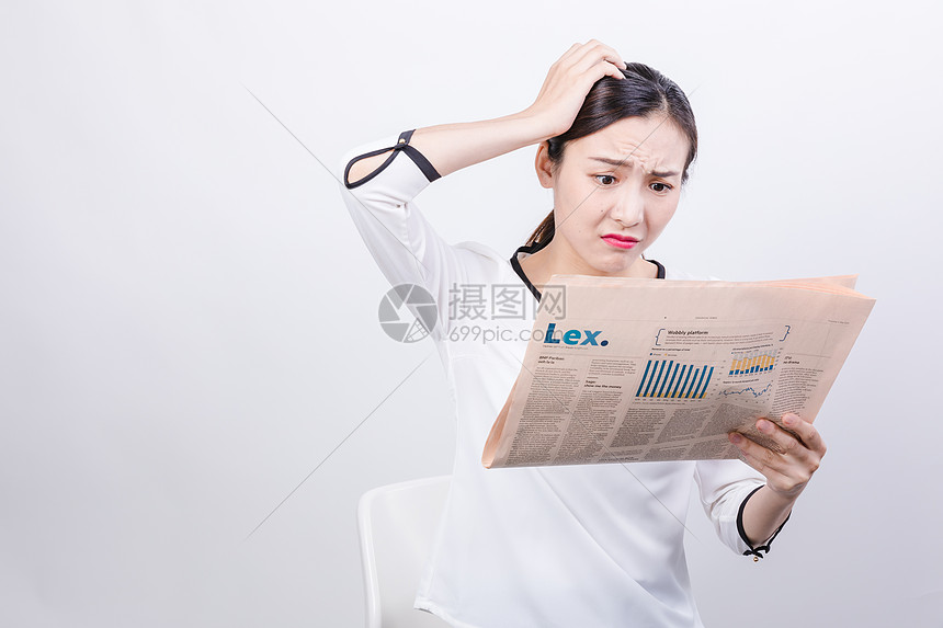 职业女性看报纸苦恼棚拍图片