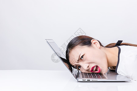 职业女性靠在电脑上棚拍图片