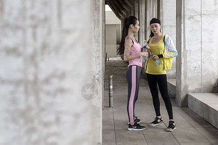 健身女子喝水两名女子运动完休息背景