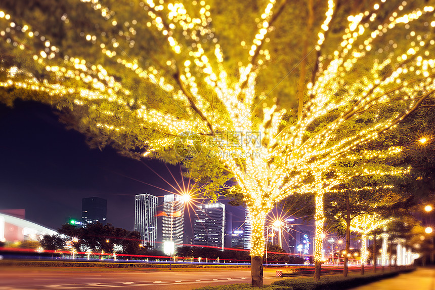 路边被灯串装扮的树城市夜景图片