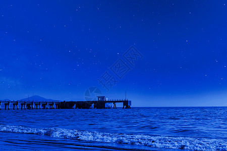 夜空下的星星星空下的海边景色背景