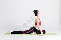坐在瑜伽垫上做瑜伽动作的女性图片