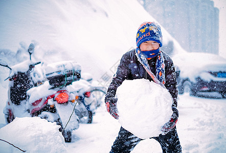 雪中堆雪球玩雪的男孩背景图片