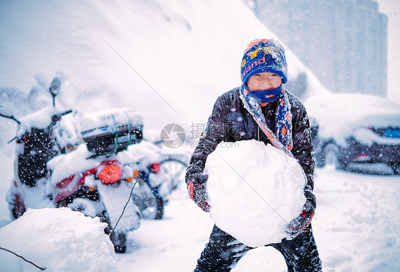 雪中堆雪球玩雪的男孩图片