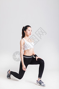 年轻女性健身力量型动作棚拍图片