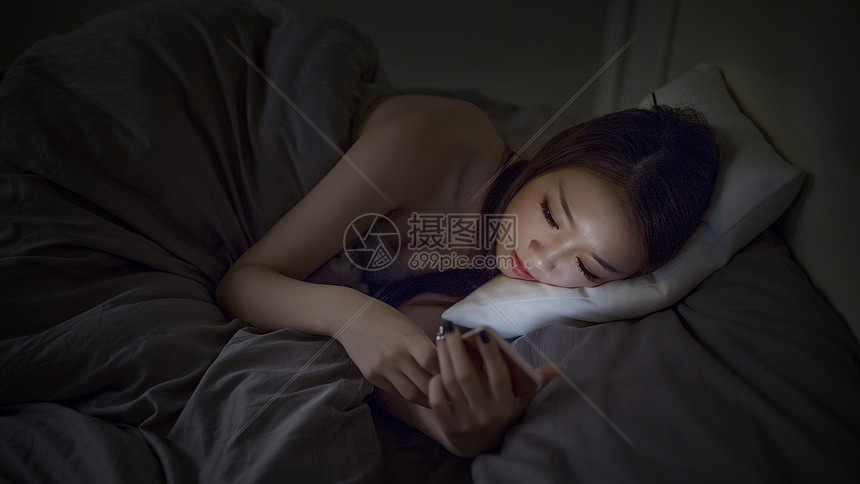 深夜睡前躺着玩手机的女生图片