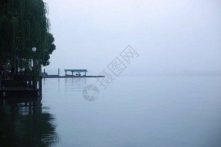 烟雨西湖烟雨朦胧的江南湖面小船摇曳背景