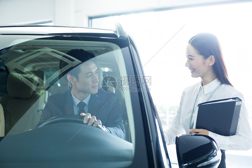 汽车销售服务人员为客户介绍汽车图片