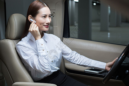 车载蓝牙耳机商务女士在商务车内使用蓝牙耳机背景