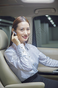 在车内戴蓝牙耳机通话的商务女性图片