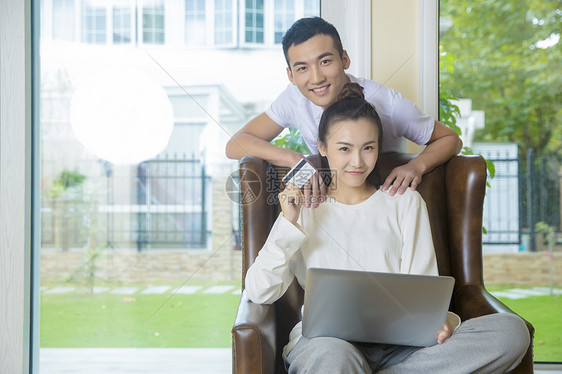 年轻夫妇在客厅用电脑网购图片
