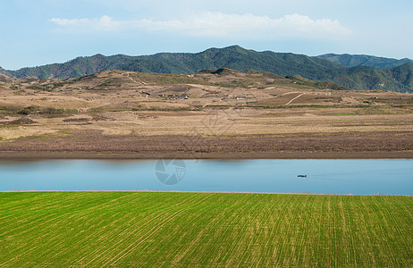 绿色山水背景鸭绿江边上的麦田河流山脉背景