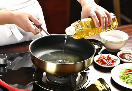 炒菜倒油植物油厨房锅高清图片