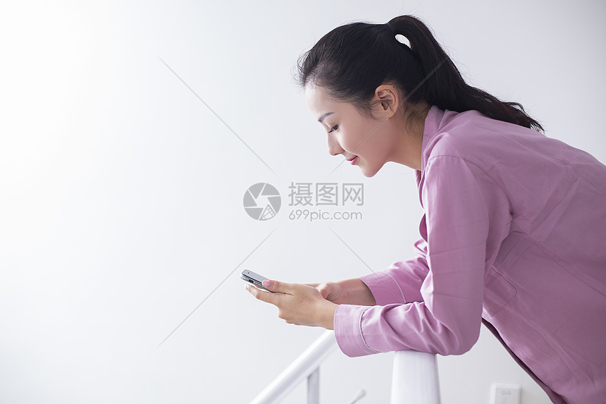 女主人在家里休息玩手机图片