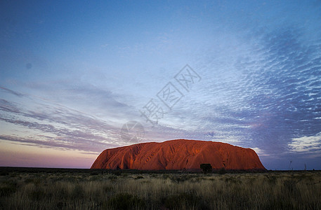 日落晚霞澳洲中部的乌卢鲁巨石背景