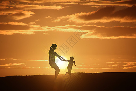 兴奋的孩子夕阳下玩耍的母子设计图片