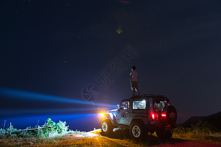 车顶行李架星空下jeep车顶上的人背景